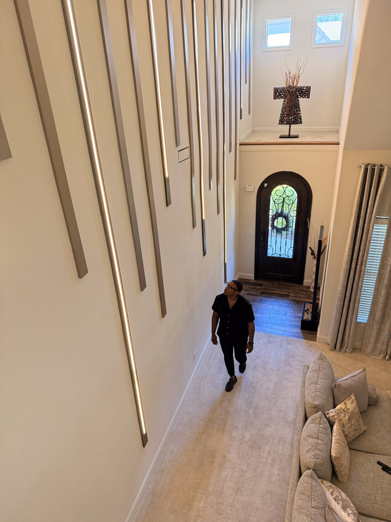 Two-story foyer with a floor-to-ceiling LED slat accent wall